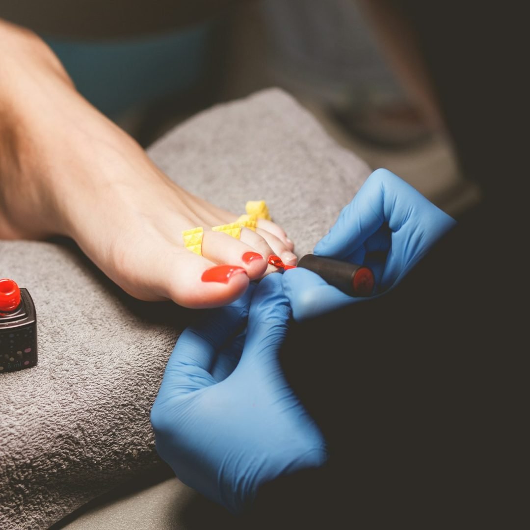 Master does pedicure for client. Pedicure process. Girl draws toenails